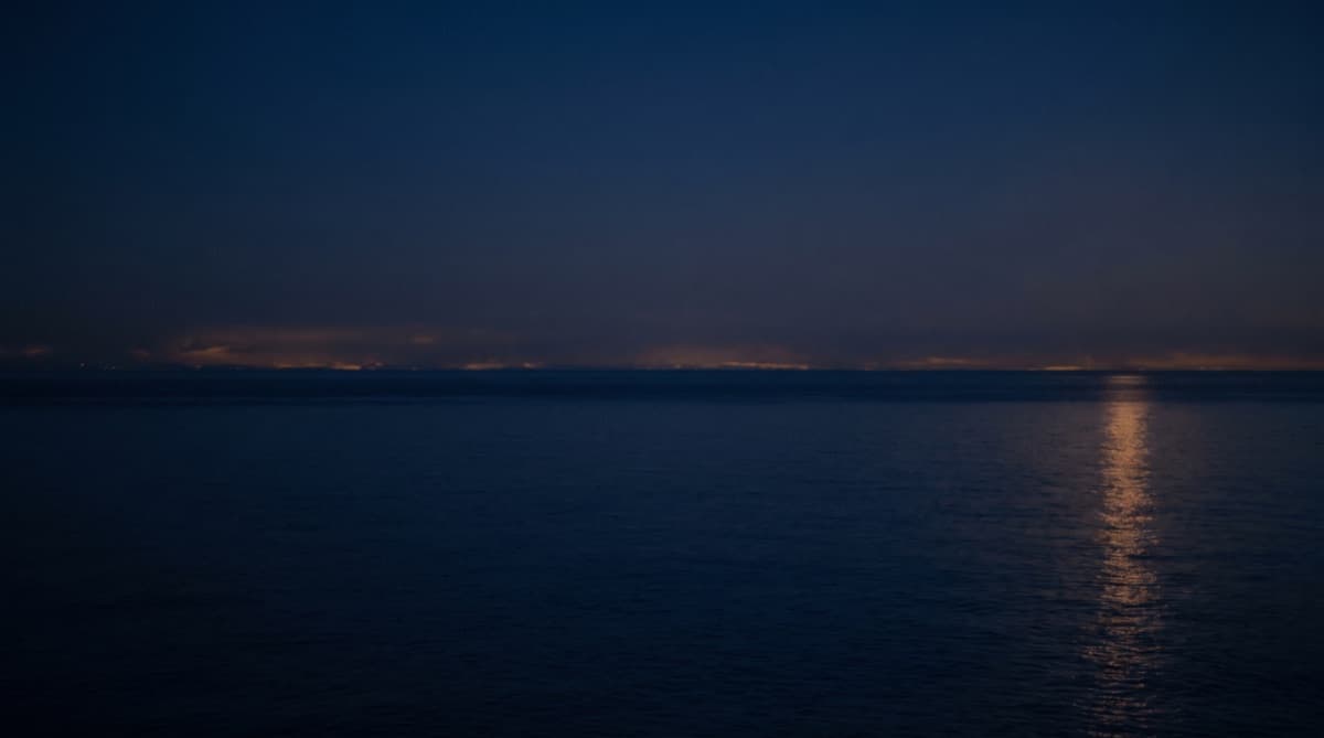 An ocean liner mid-Atlantic at dusk beneath a golden sky